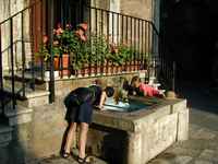 Taking a drink from the local water supply at the step of the medieval church